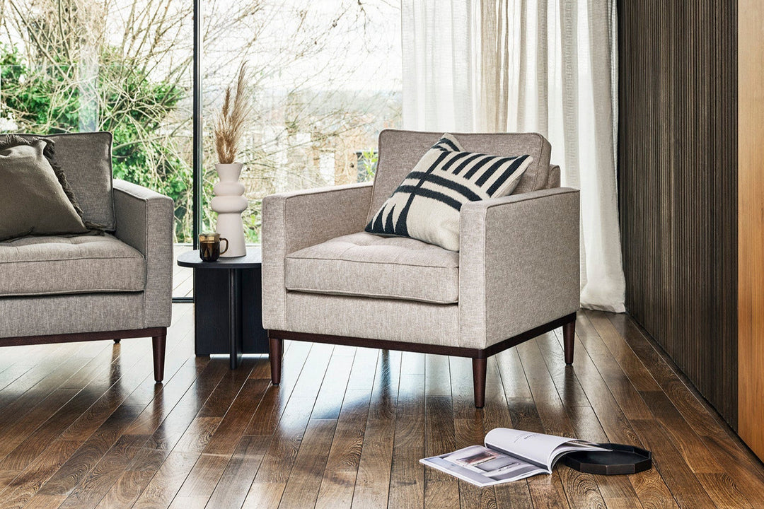 Gray armchair with a striped pillow in a living room setting.