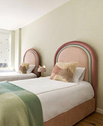 Load image into Gallery viewer, Bedroom with two pink beds against a light green wall.