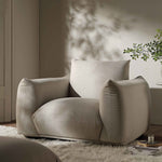 Load image into Gallery viewer, Beige armchair in a modern living room setting with a plant and coffee table.