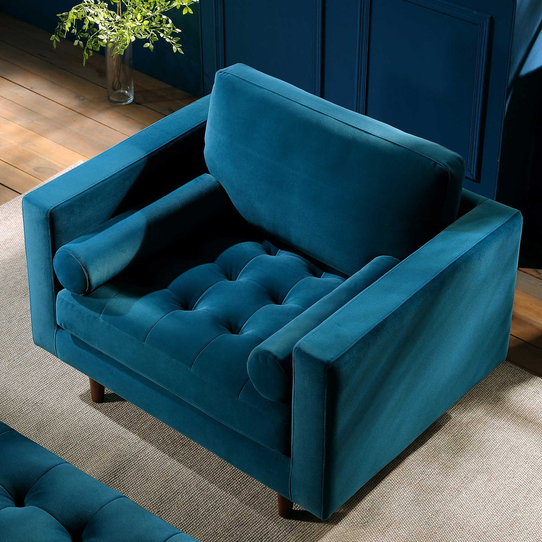 Blue velvet armchair in a room with wooden floor and plant