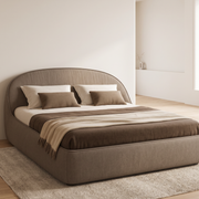 Corvella upholstered bed in taupe-brown fabric in a bright bedroom, side view