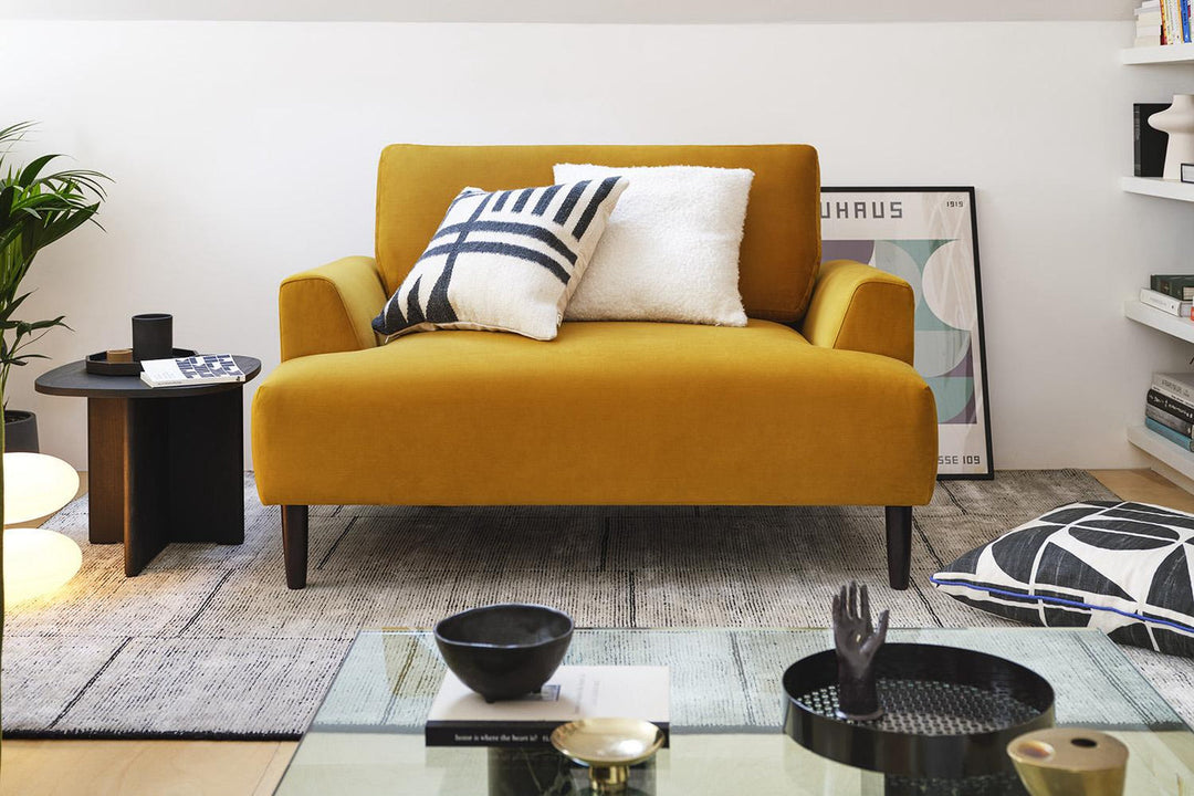 Yellow sofa with decorative pillows in a living room setting