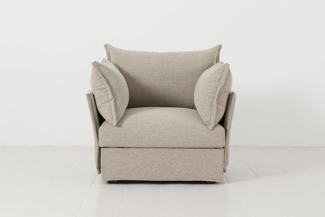 Beige armchair with a pillow on a white background