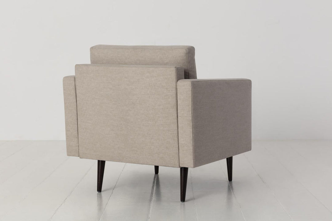 Beige armchair on a white floor with a white background