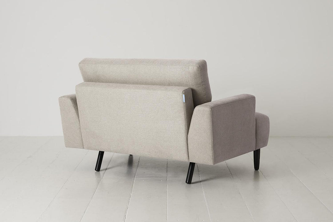 Beige armchair on a white floor with a white wall background