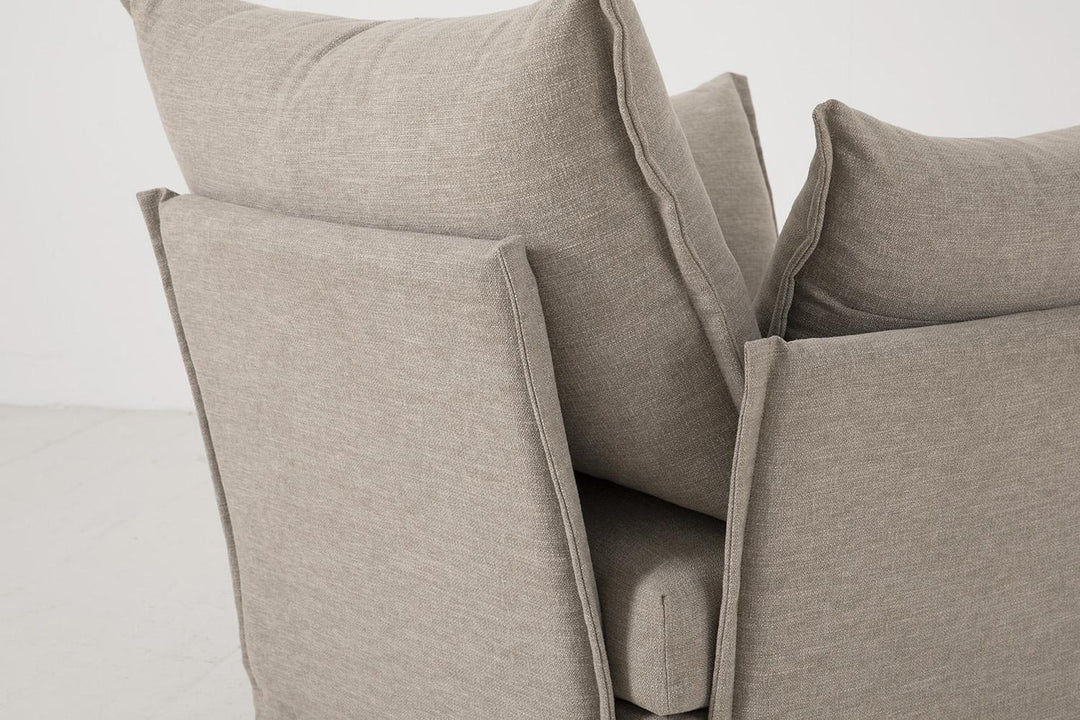 Close-up of beige fabric pillows on a sofa against a white background