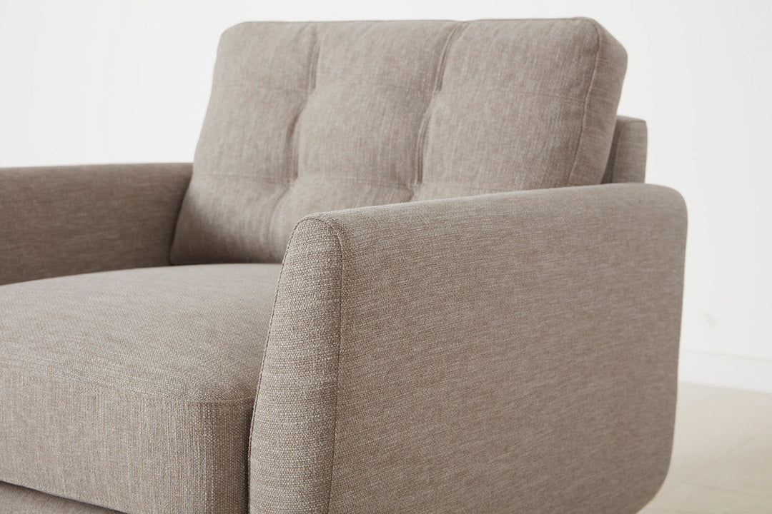 Close-up of a beige fabric armchair on a white background