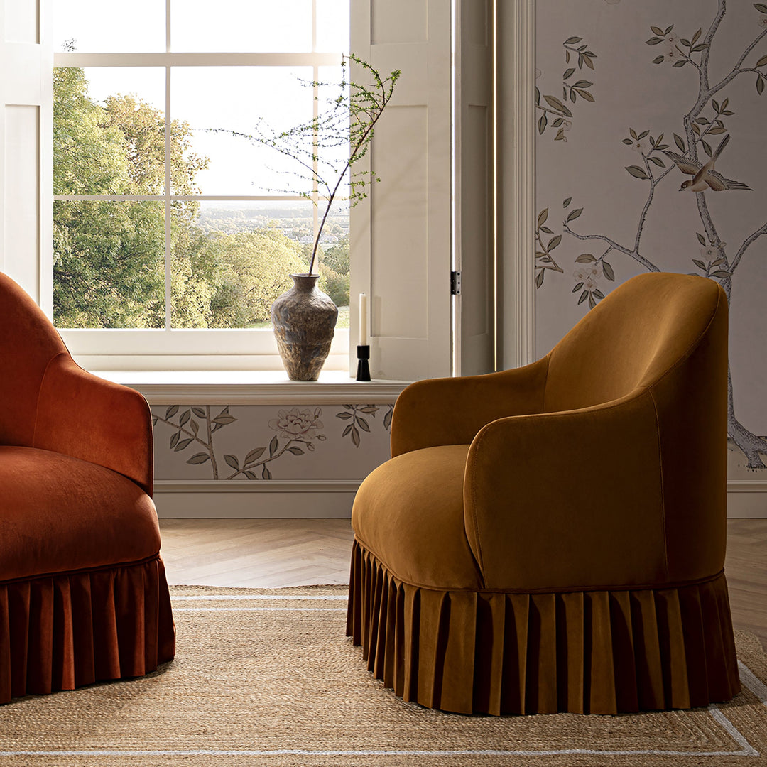Two upholstered chairs in a room with a window and decorative wall.