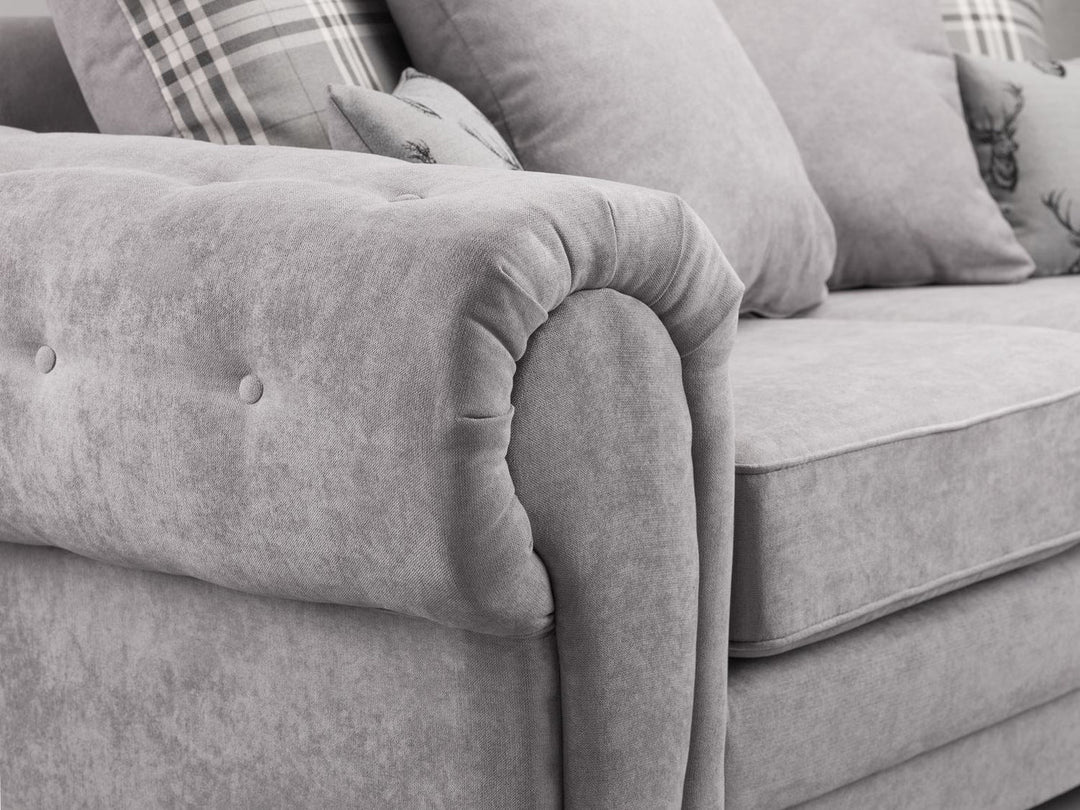Gray sofa with tufted backrest and decorative pillows