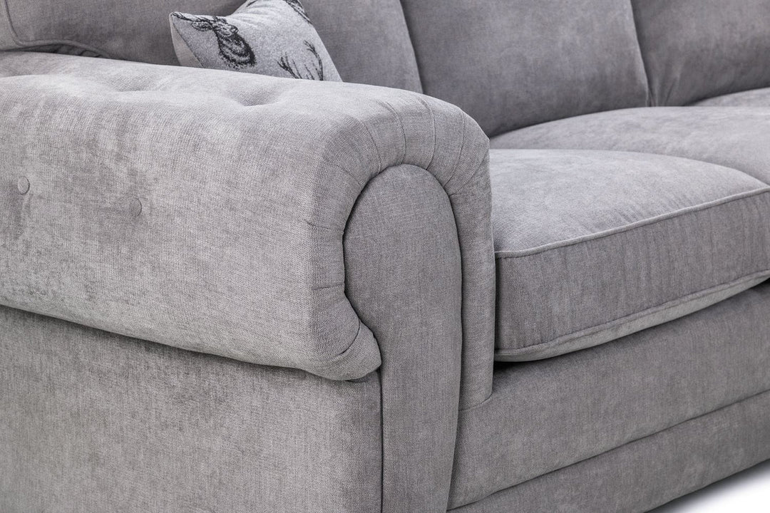 Gray sofa with tufted backrest and cushions on a white background