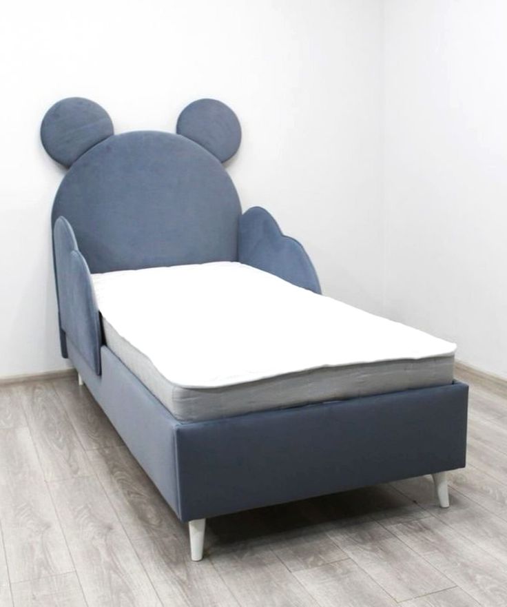 Blue children's bed with mouse ears design on a white background