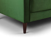 Close-up of a green upholstered chair with a wooden leg on a neutral background