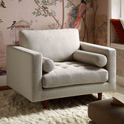 Gray armchair in a room with floral wallpaper