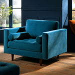 Load image into Gallery viewer, Blue armchair in a room with large windows and a plant.
