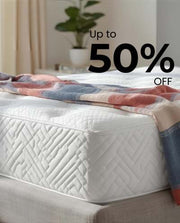 White mattress with a colorful blanket on a bed in a bedroom setting, featuring a discount text overlay.