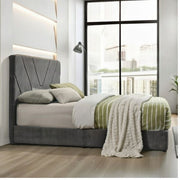 Modern bedroom with a gray upholstered bed and striped bedding.