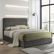 Modern bedroom with a gray upholstered bed and striped bedding.