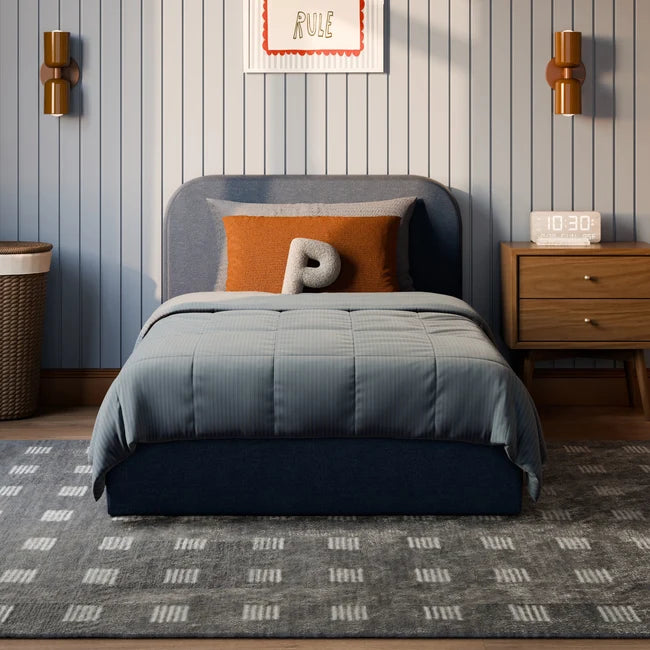 Bedroom with a bed, nightstand, and decorative elements on a striped wall.