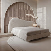 Modern bed with unique headboard design in a minimalistic room.