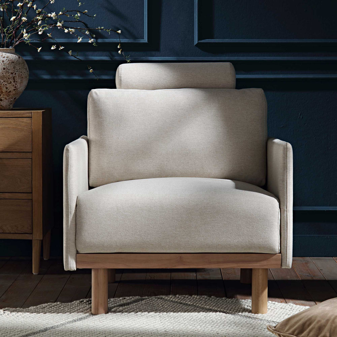 Beige armchair in a room with dark blue walls and wooden furniture.