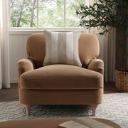 Brown armchair with a patterned pillow in a room with a window and plant