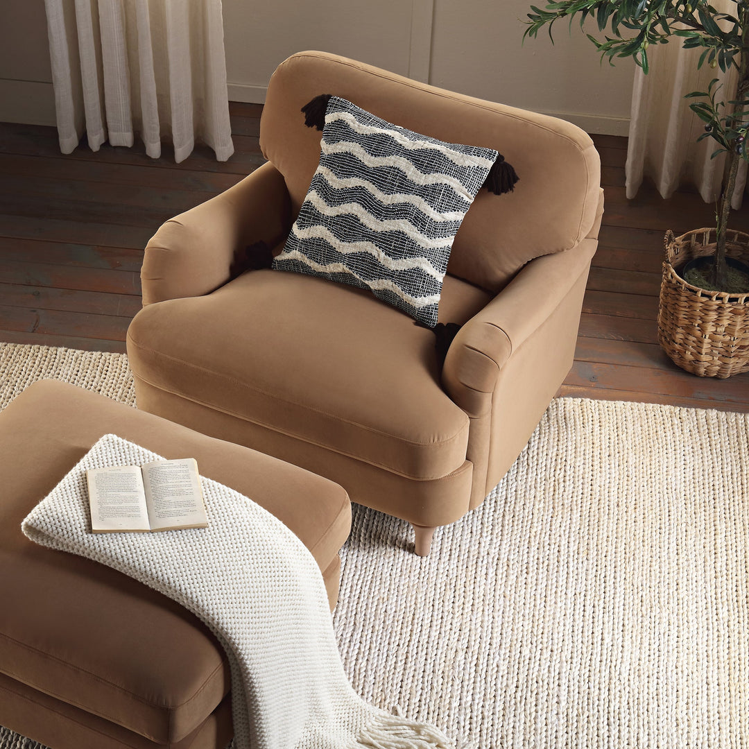 Beige armchair with a patterned pillow in a cozy living room setting.