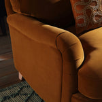 Load image into Gallery viewer, Brown upholstered chair with a decorative pillow on a wooden floor.
