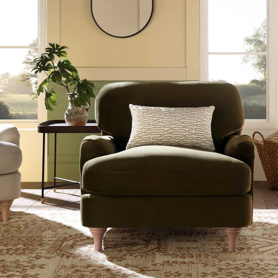 Brown armchair with a patterned pillow in a bright living room.