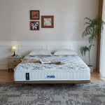 Load image into Gallery viewer, HUG mattress in a bedroom setting with decor elements.