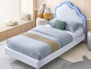 Children's bed with blue headboard and bedding in a room setting