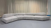 Gray sectional sofa in a room with beige curtains