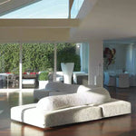 Load image into Gallery viewer, Modern white sofa in a stylish living room with large windows.
