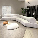 Load image into Gallery viewer, Modern living room with a large white sectional sofa, ottoman, and decorative pillows.
