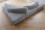 Load image into Gallery viewer, Gray sectional sofa on a wooden floor
