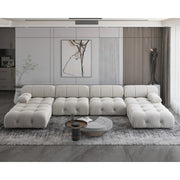 Modern living room with a large white sectional sofa, coffee table, and decorative elements.