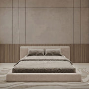 Beige bed in a room with wooden paneling