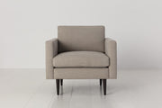 Beige armchair on a white floor with a light gray background