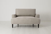 Gray armchair on a white floor with a white wall background