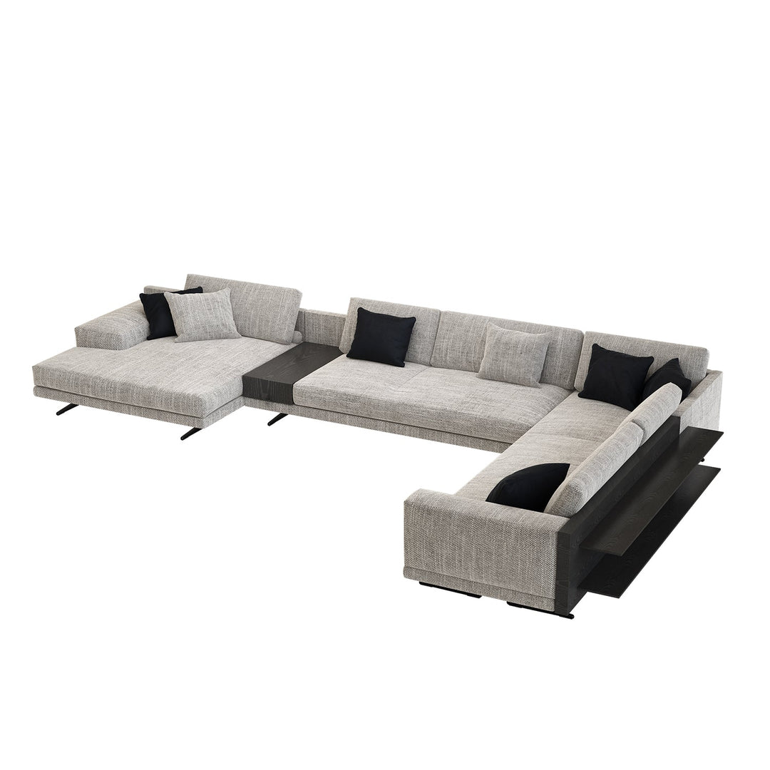 Gray sectional sofa with black cushions on a white background