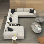 Load image into Gallery viewer, Gray sectional sofa with black pillows in a modern living room setting.
