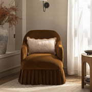 Brown armchair with a white pillow in a room with a window and side table.