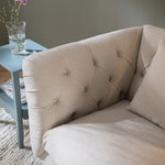 Load image into Gallery viewer, Beige sofa with tufted backrest in a living room setting
