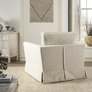 Beige armchair in a living room setting with a side table and decor items.