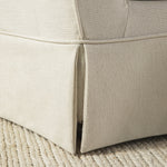 Load image into Gallery viewer, Close-up of a beige upholstered chair corner on a textured surface
