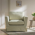 Load image into Gallery viewer, Striped armchair in a room with a table and decorative items.
