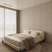Modern bedroom with a beige bed and neutral decor