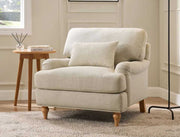 Beige armchair in a room with a wooden side table and decorative items.