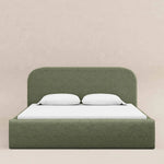 Load image into Gallery viewer, Green upholstered bed with white bedding on a beige background
