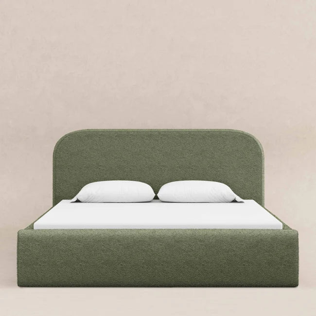 Green upholstered bed with white bedding on a beige background