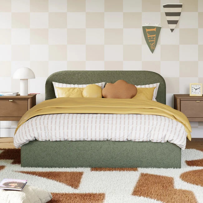 Bedroom with a green bed, yellow blanket, and patterned rug.